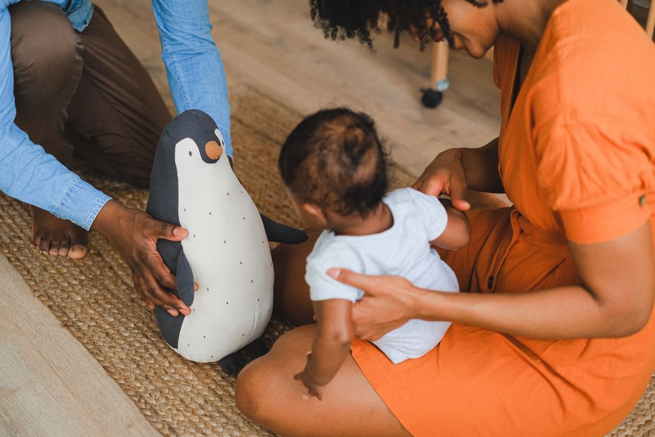 Un bébé joue sur un tapis avec ses parents