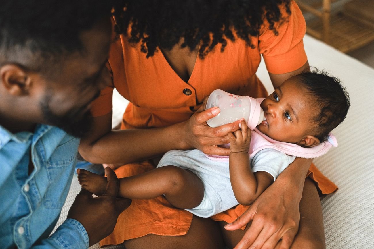 Des parents donnent le biberon à leur bébé
