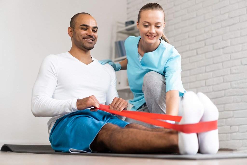 Kinésithérapeute guidant un exercice avec un élastique